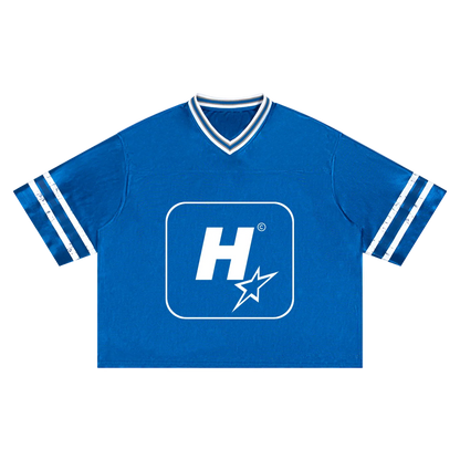 A royal blue short-sleeve V-neck t-shirt with white stripes on the sleeves and a large white 'H' logo with a star inside a rounded square on the chest.