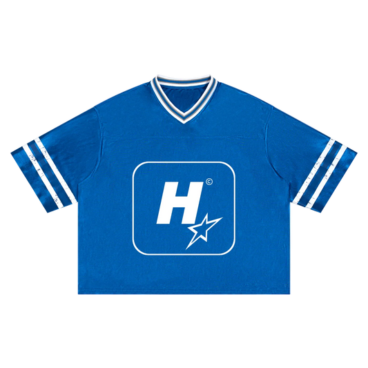 A royal blue short-sleeve V-neck t-shirt with white stripes on the sleeves and a large white 'H' logo with a star inside a rounded square on the chest.