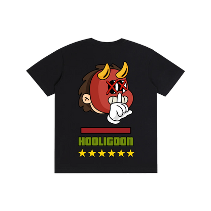 A black short-sleeve t-shirt with a graphic of a cartoon devil monkey wearing a red mask and making a shushing gesture. Below the graphic, the word 'HOOLIGOON' is printed in green with five yellow stars underneath, all on a solid white background.